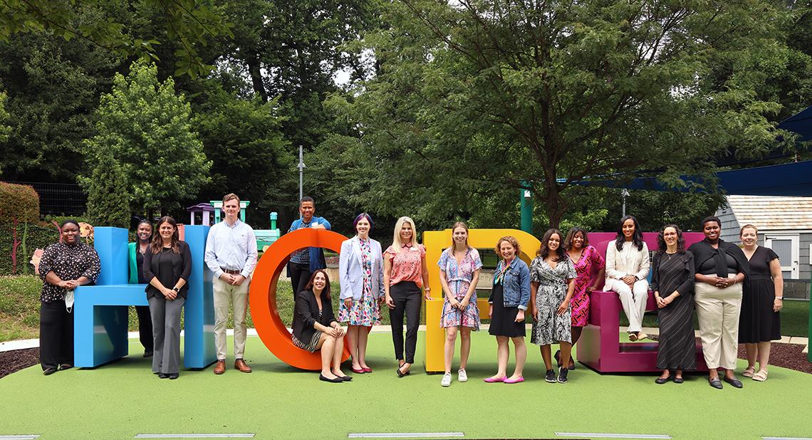 Staffers stand around the HOPE statue at the playground