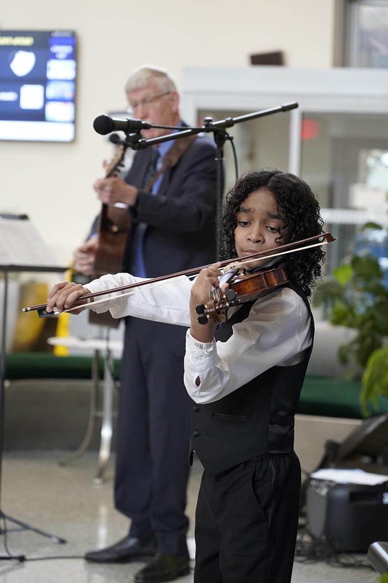 Caesar plays the violin alongside Collins, who is playing the guitar.