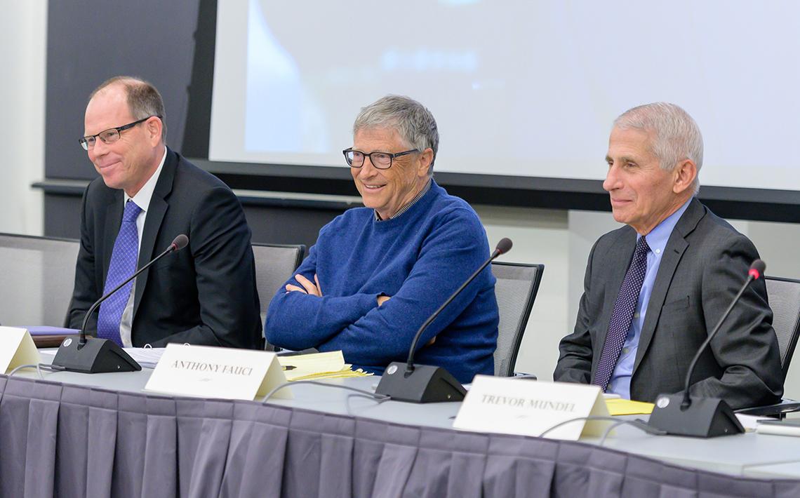 Fauci and Gates sit next to each other at a conference table.