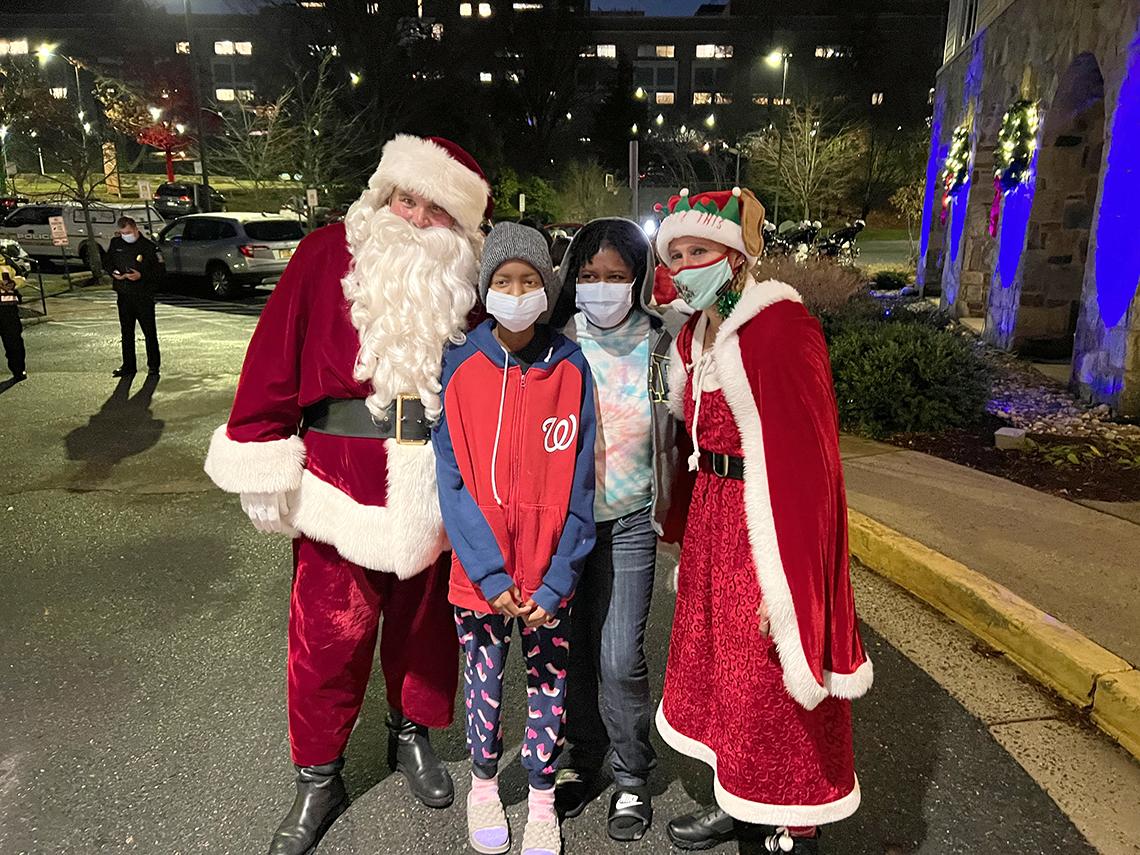 Santa and Mrs. Claus take a photo with two Inn residents