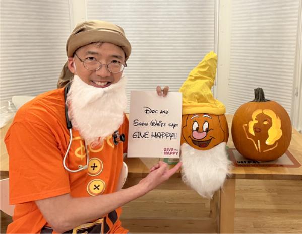 Dr. Chiang with skullcap and fake beard along side a smiling pumpkin with skullcap and fake beard ala "Happy" of Disney's Snow White 