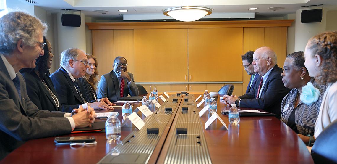 Side view of conference table with Sen. Cardin on staff on one side and NIH leaders on the other in the CC Medical Board Room.