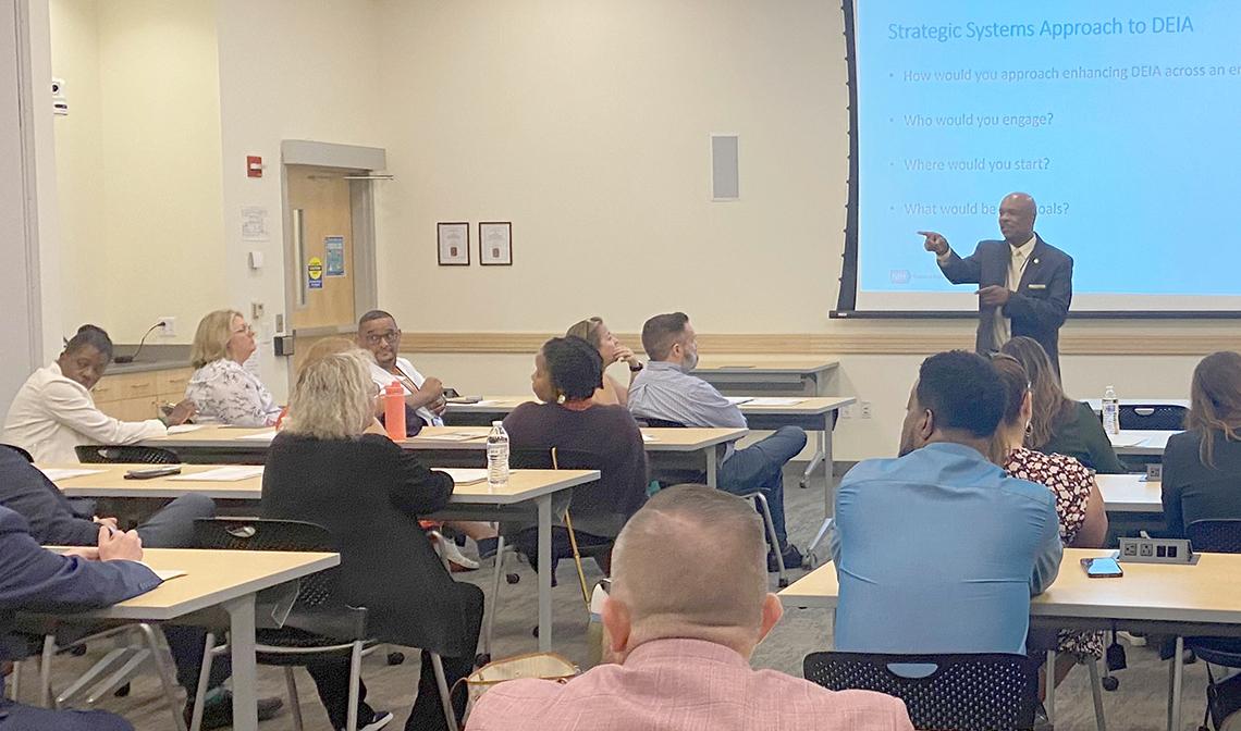 Johsnson speaks to a room full of fellows sitting at desks