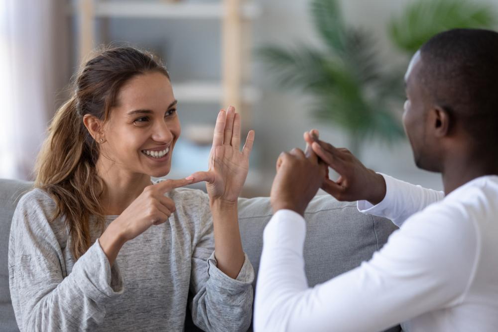 Two people speaking to each other using sign language