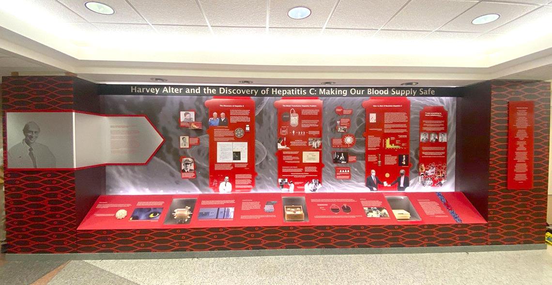 Wide glass-enclosed exhibit with Alter photo, title and artifacts