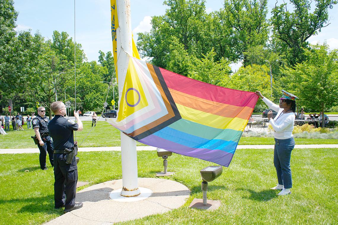 Robinson and Mehlhaff unfurl the Pride flag