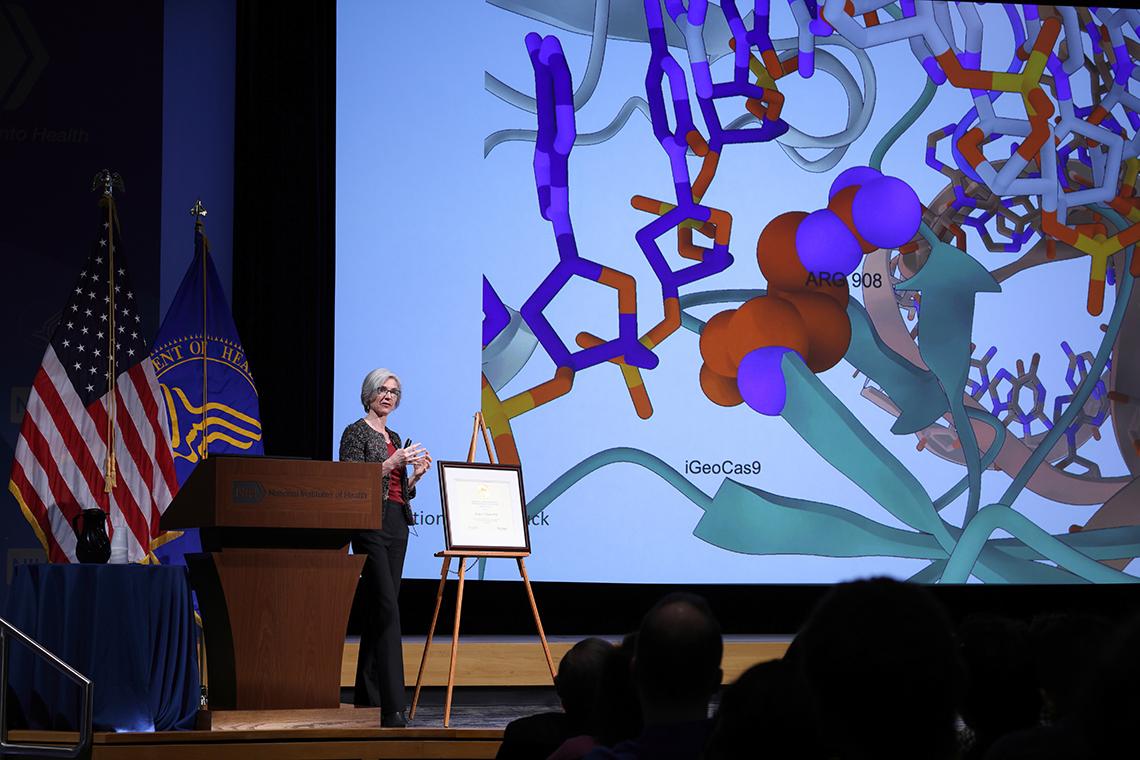 Doudna speaks in front of a large slide