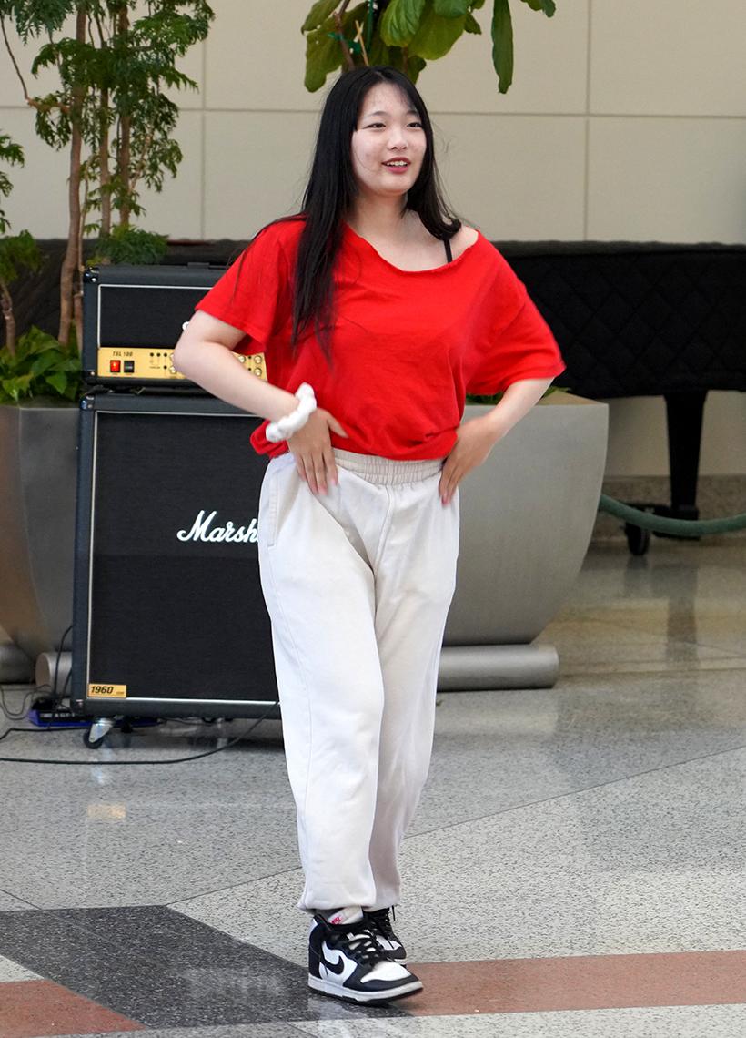 Woman in a red top and white pants