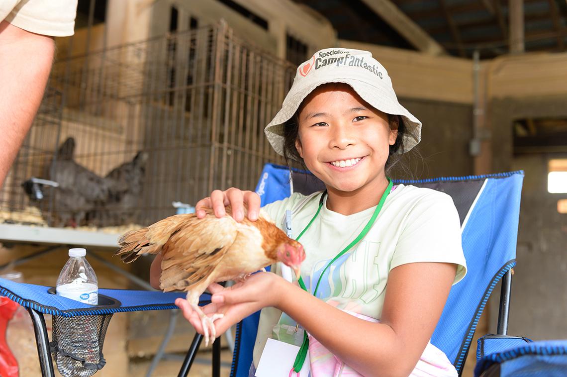 A girl holds a chicken