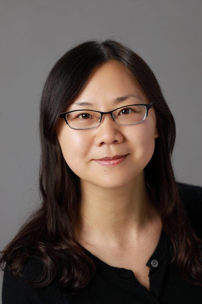 Headshot of Feng, who wears glasses and a black sweater.