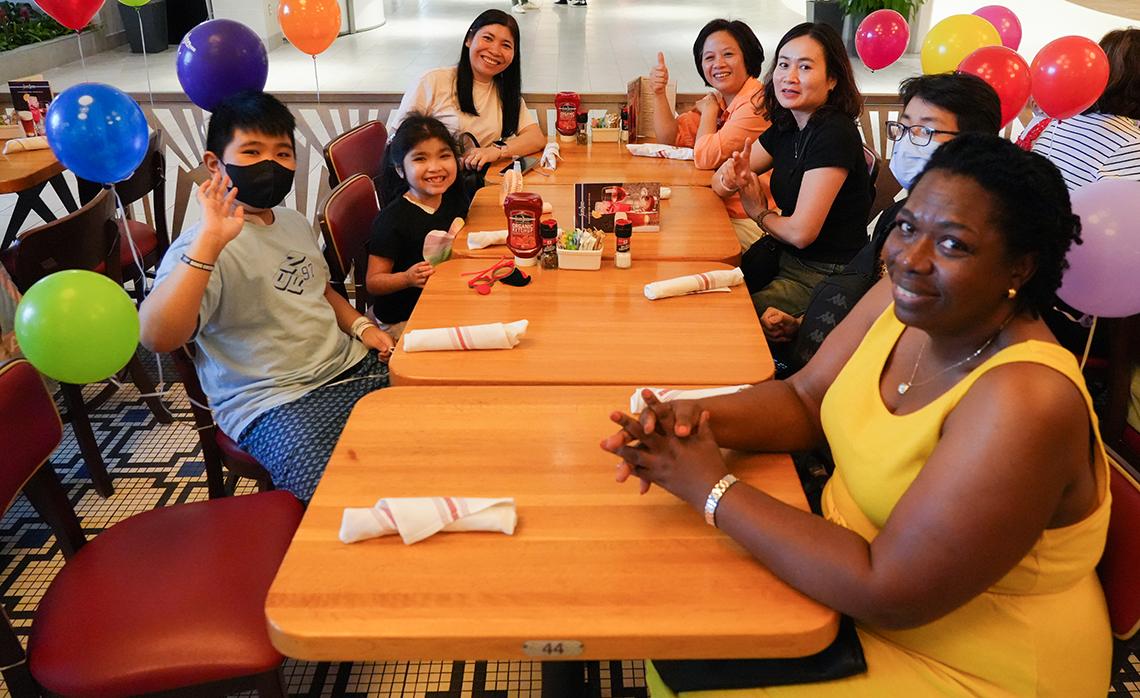 Adults and kids seated around a restaurant table