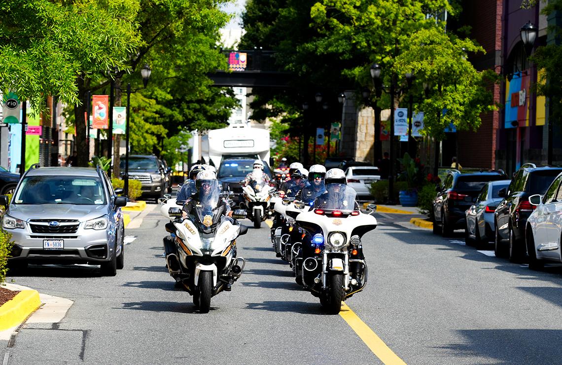 Two rows of motorcycles: 'police elves' drive up the street.