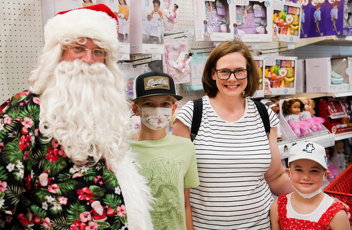 A mom and two children pose with Santa.