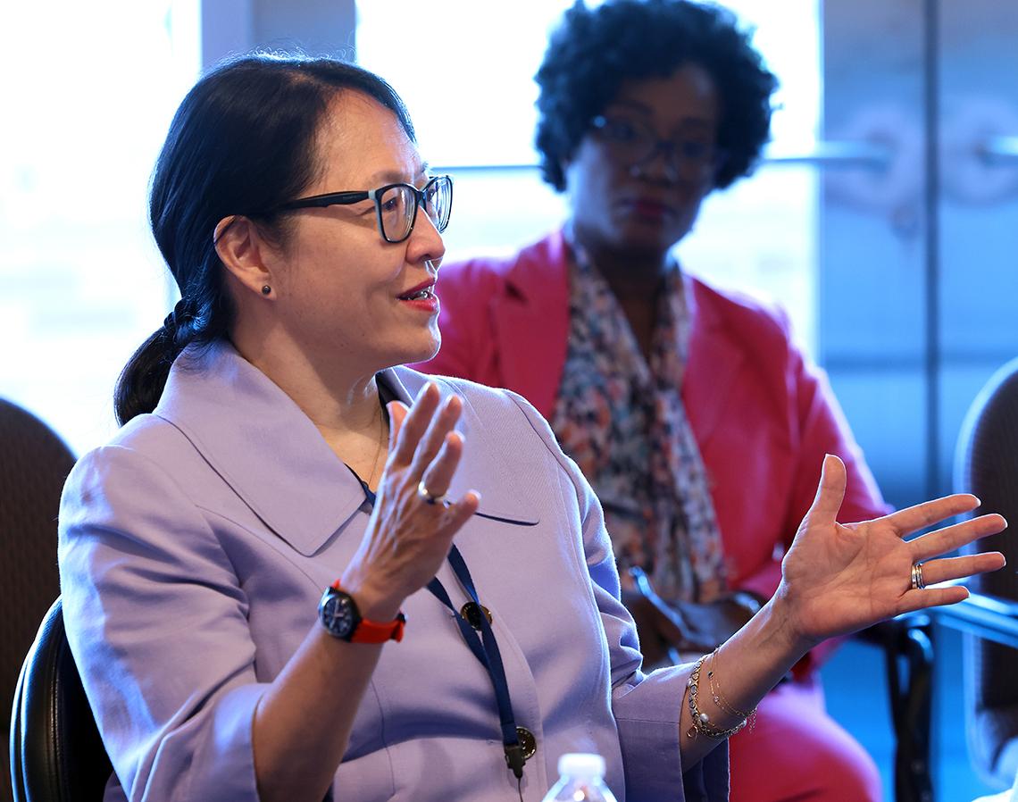 Pao sits talking in Board Room, her hands extended