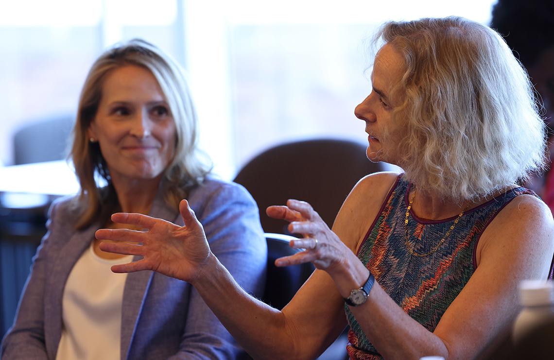 Volkow speaks holding up hands, seated at boardroom table