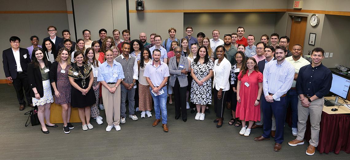 A large group of people posing for a photo in a conference room.