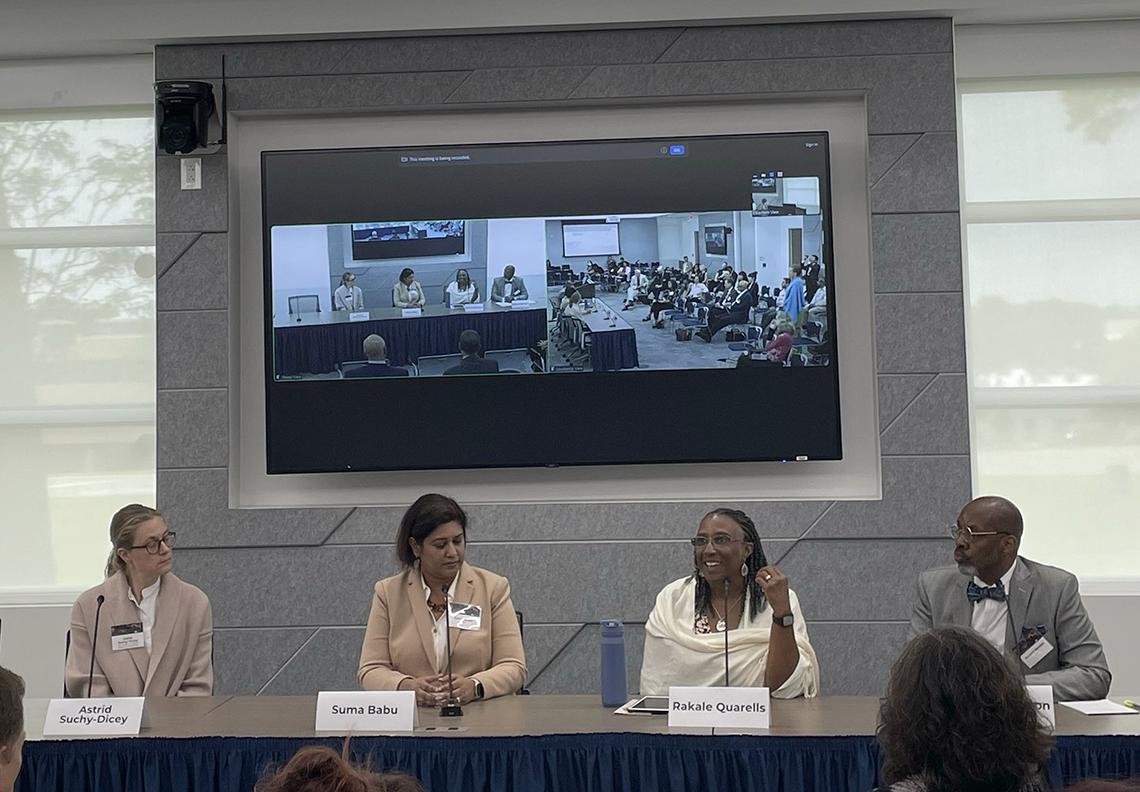 Panelists sit at a table