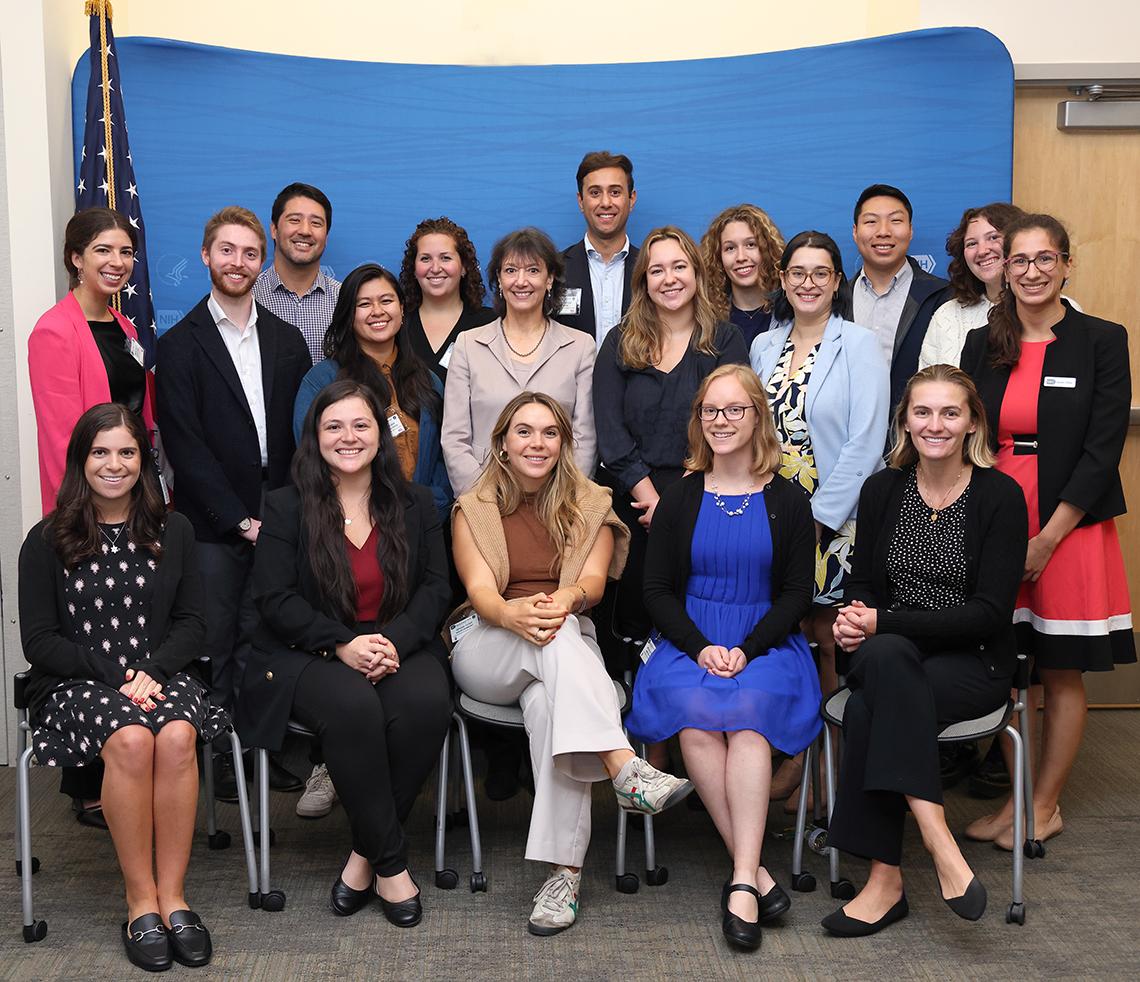 Group photo of Hill staffers with NIH staff, including Dr. Bertagnolli, against blue backdrop