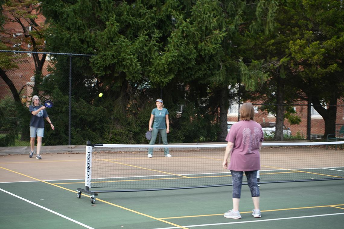 Pickleballers play on the court