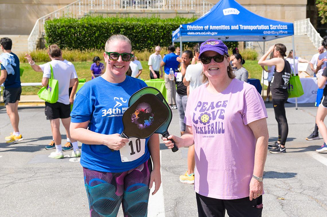 Hackett and Lee hold pickleball paddles