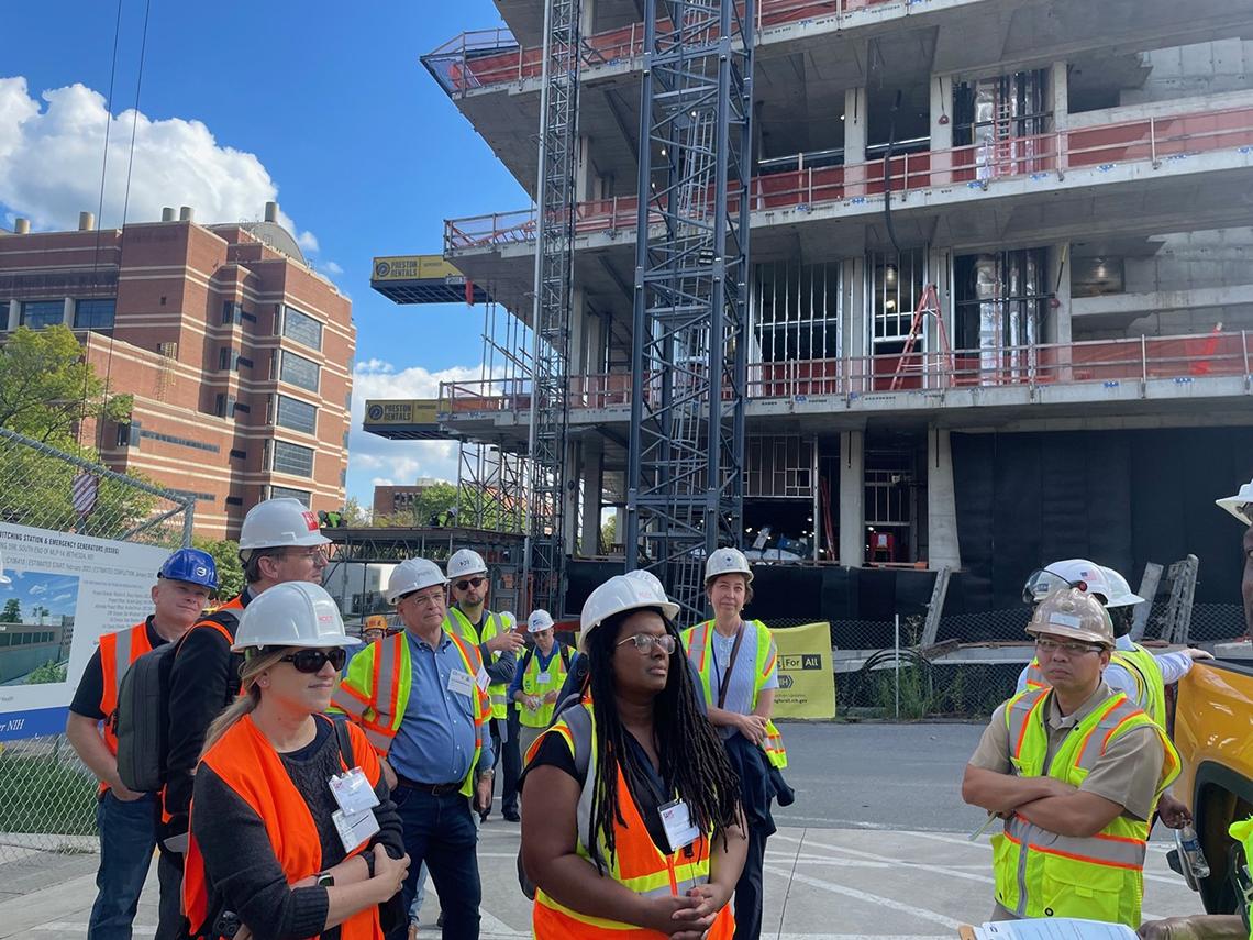 SAME members stand in front of the VRC expansion and listen to an update on it