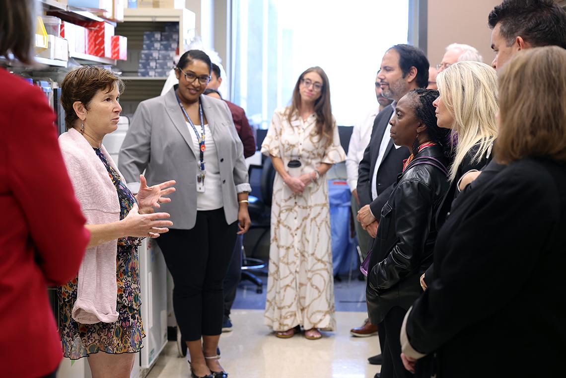 A scientists talks to group in the lab.