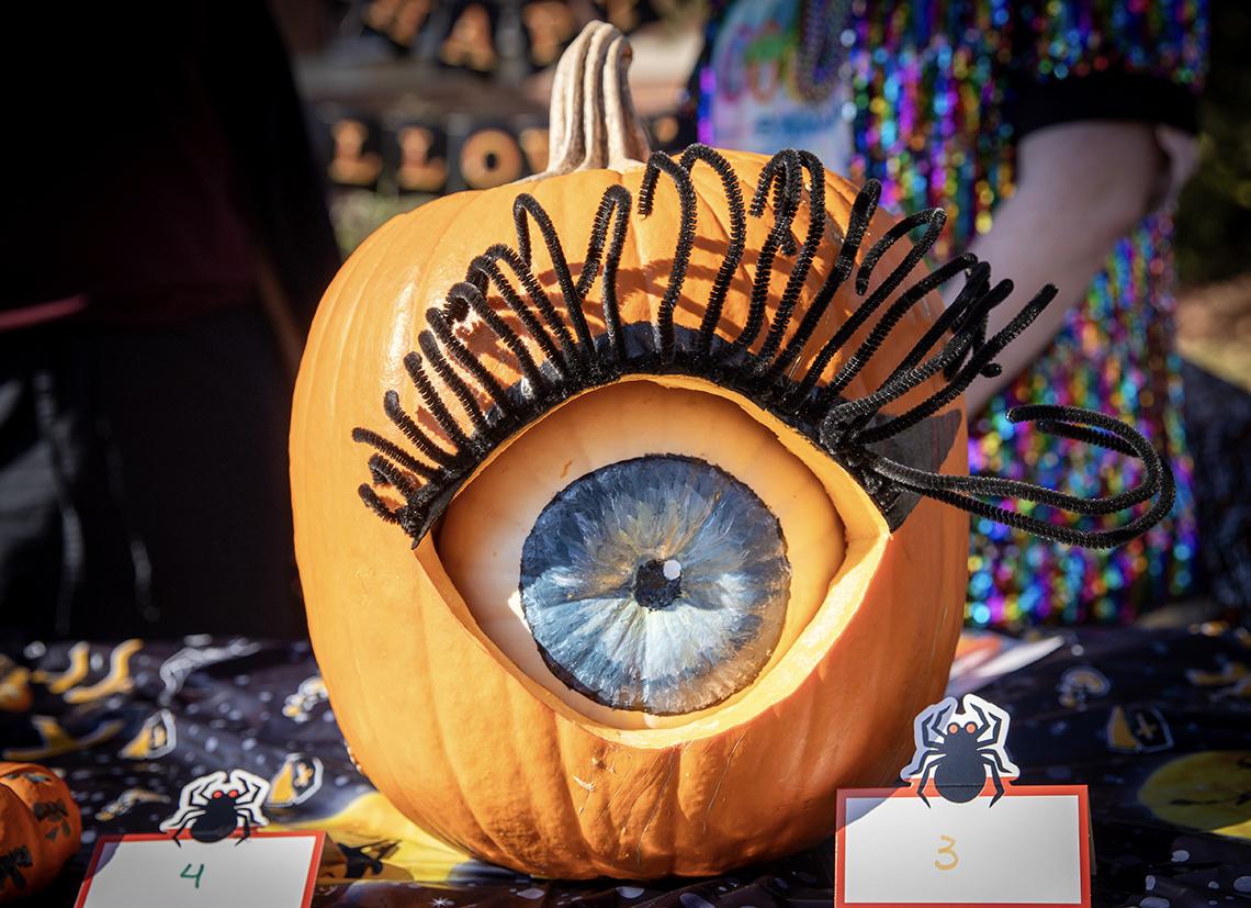 A large pumpkin carved and decorated to resemble an eye.