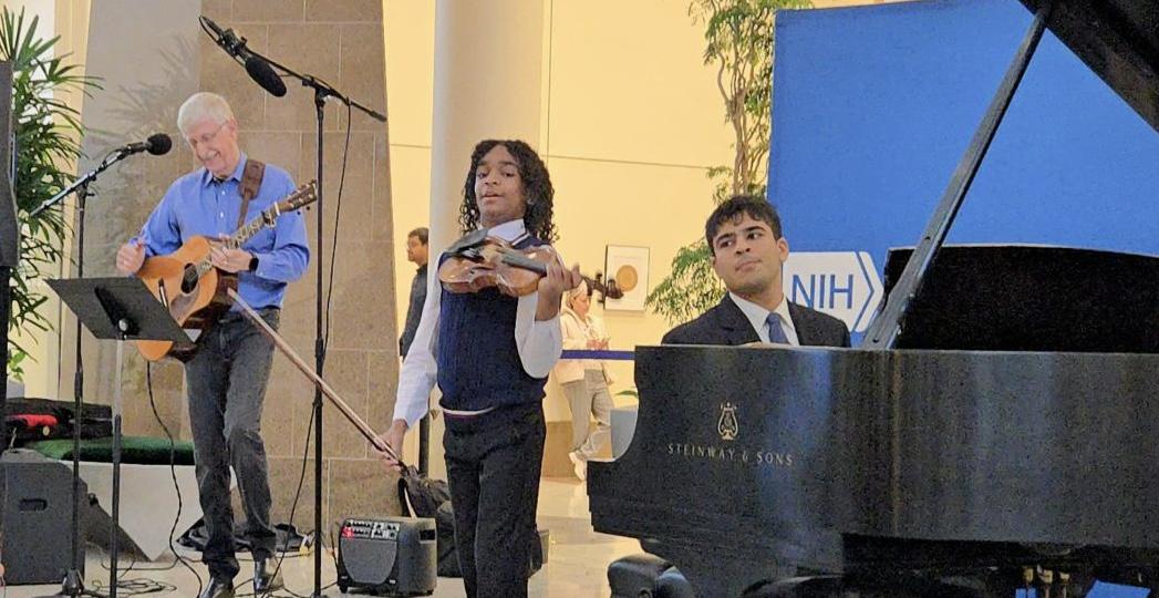 Sant stands with his violin, flanked by Collins on the guitar and Mahotra on the piano.