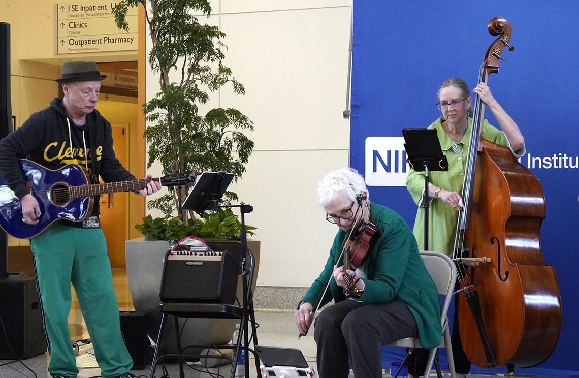 Three of the Dulcetones mid-performance, playing guitar, violin and bass.