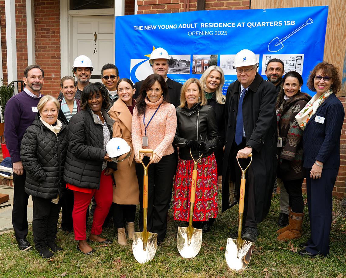 A group photo featuring the event's attendees in front of the quarters