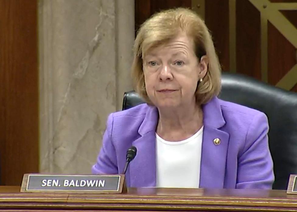 Baldwin, seated on the leadership platform of a Senate hearing room