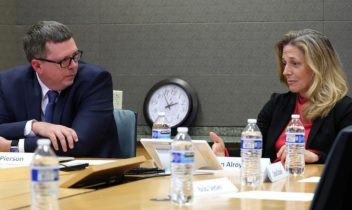 Alroy-Preis chats with VRC Director. They are seated side-by-side at a long table.