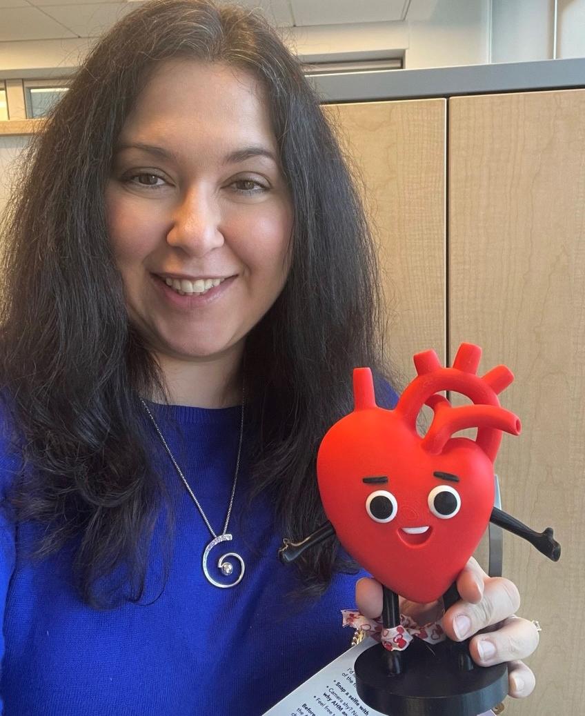 Ammary-Risch smiles, holding heart mascot Cardi-O