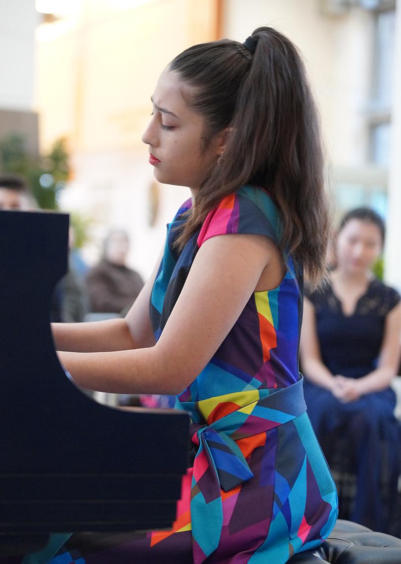 Wampler in colorful dress playing piano