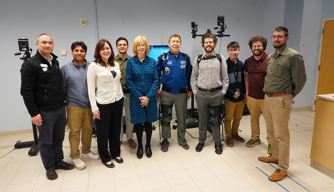 Group poses together with astronaut Barratt in the middle