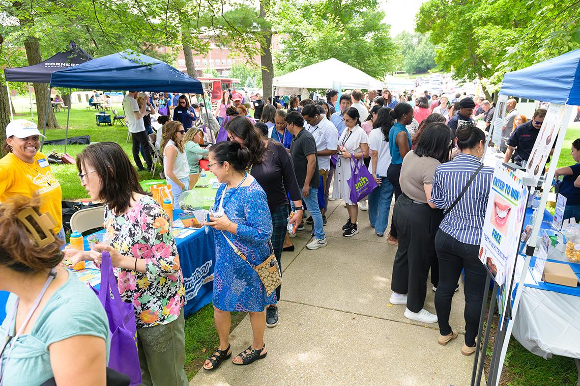 BBQ attendees walk past informational tables