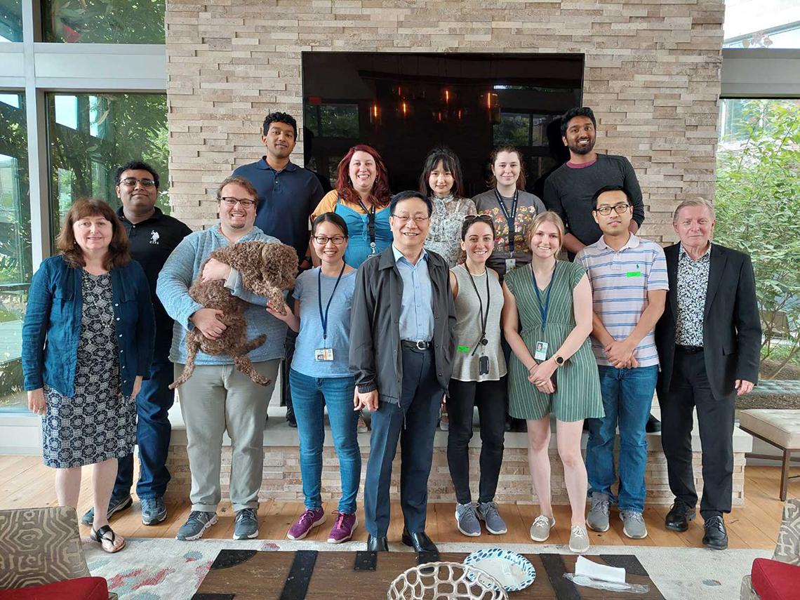 A team of researchers pose together inside someone's house.