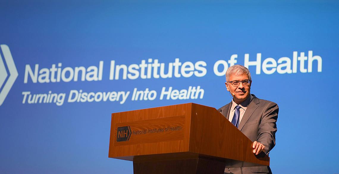 Dr. Bhattacharya speaks at podium