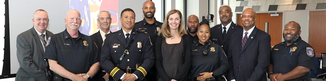 McGowan poses for a photo with a group of people in police uniforms.