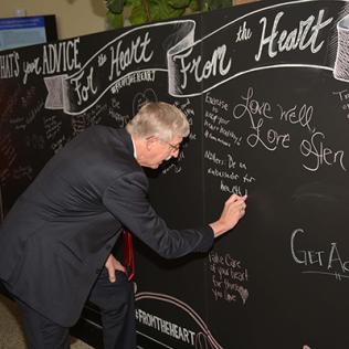 Dr. Collins writes message on blackboard.