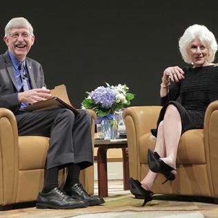 Collins and Rehm, seated on stage, smile as they interact with the audience.