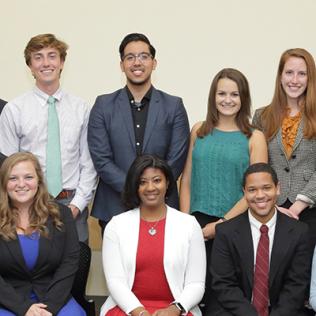 Large group of people smiles into camera.