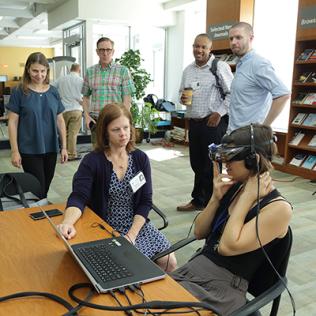 Woman demonstrates virtual reality goggles.