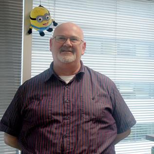  Alastair Thomson in his office with a minion balloon behind him