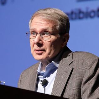 Dr. Lewis speaks at podium.