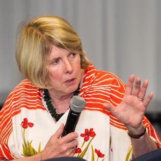 Jamison holds microphone while speaking to audience.