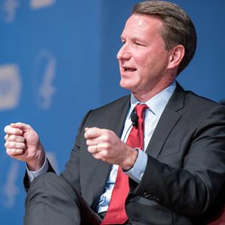 Dr. Sharpless gestures with his hands as he speaks to the audience.