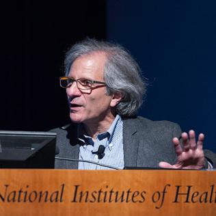 Dr. Ira Mellman speaks at the podium.