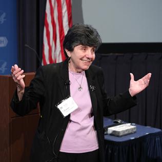 Dr. Catherine DeAngelis speaking and gesturing with her hands raised.