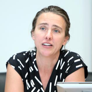 Dr. Anya Plutynski, speaking from behind a laptop.